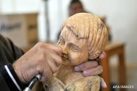 A Palestinian carpenter carves a wooden sculpture of baby Jesus at a workshop in the West Bank town of Bethlehem, on December 20, 2012. The traditional birthplace of Jesus Christ prepares to celebrate Christmas later thi...