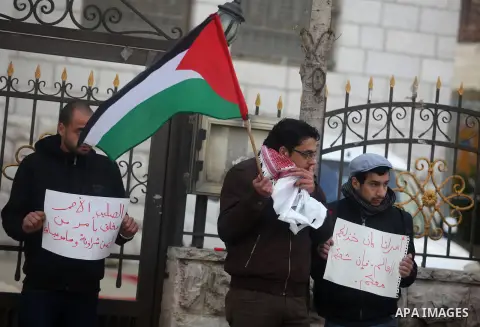 Palestinian protesters hold posters and a sign reading "ICRC, do your work or leave" during a demonstration in support of Palestinian prisoners held in Israeli jails, some of whom are observing a hunger strike, outside t...