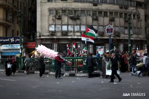 People walk past a stall displaying Egyptian flags for sale at Tahrir Square where protesters opposing President Mohamed Mursi are camping in Cairo December 20, 2012. Egyptian Islamist groups are planning a mass protest...