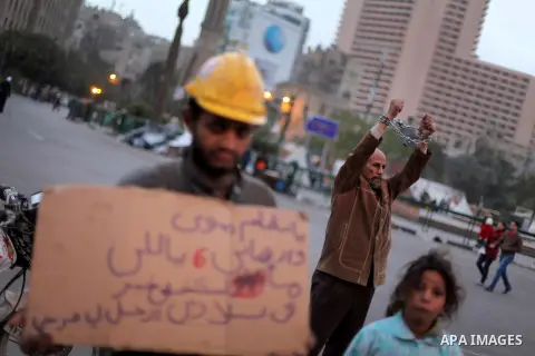 An Egyptian protester with chains around his wrists stands at Tahrir Square where protesters opposing President Mohamed Mursi are camping in Cairo December 20, 2012. Egyptian Islamist groups are planning a mass protest i...
