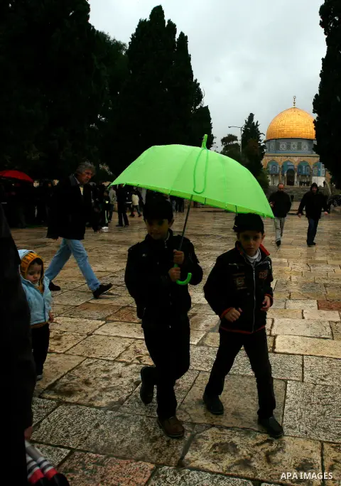 Palestinian worshippers walk in front of the Dome of the Rock mosque following Friday prayer at al-Aqsa mosque, Islam's third holiest site, in the old city of Jerusalem on December 21, 2012. Photo by Mahfouz Abu Turk