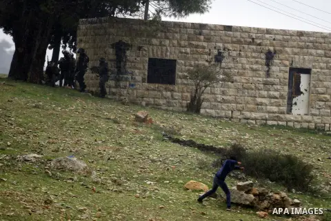 A Palestinian protester throws stones at Israeli soldiers during clashes near the Jewish settlement of Halamish in the West Bank village of Nabi Saleh, near Ramallah December 21, 2012. Photo by Issam Rimawi