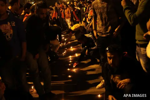 Egyptian protesters place candles as they gather at Tahrir square in Cairo, Egypt, Friday, Dec. 21, 2012. Running clashes between rival protesters erupted in Egypt's second city Alexandria, on the eve of the final round...