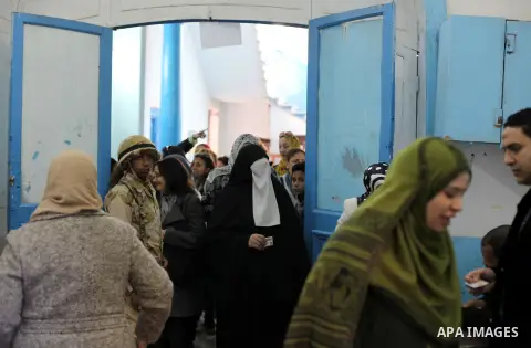Egyptian women queue with other voters at a polling station during the second round of a referendum on a new draft constitution in Giza, south of Cairo, on December 22, 2012. Egyptians are voting in the final round of a...