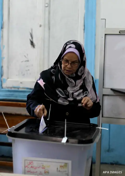 An Egyptian woman casts her ballot at a polling station during the second round of a referendum on a new draft constitution in Giza, south of Cairo, on December 22, 2012. Egyptians are voting in the final round of a refe...