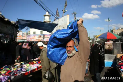 A Palestinian vendor carries his goods at the saturday's popular market in Rafah southern Gaza strip on 22 December 2012. Normal life in Gaza resumed remarkably fast after a ceasefire agreement was announced following ei...