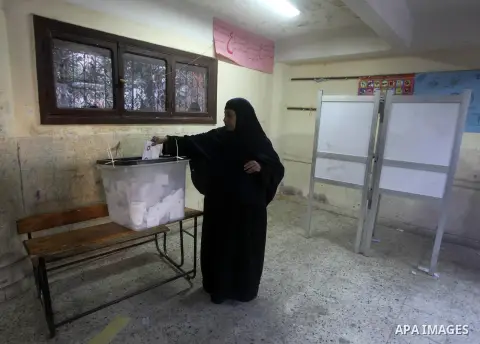 An Egyptian woman casts her ballot at a polling station during the second round of a referendum on a new draft constitution in Giza, south of Cairo, on December 22, 2012. Egyptians are voting in the final round of a refe...