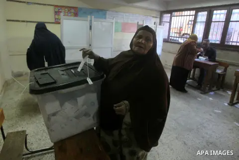 An Egyptian woman casts her ballot at a polling station during the second round of a referendum on a new draft constitution in Giza, south of Cairo, on December 22, 2012. Egyptians are voting in the final round of a refe...