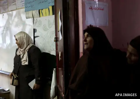 Egyptian women queue with other voters at a polling station during the second round of a referendum on a new draft constitution in Giza, south of Cairo, on December 22, 2012. Egyptians are voting in the final round of a...