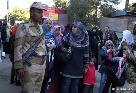 Egyptian women queue with other voters at a polling station during the second round of a referendum on a new draft constitution in Giza, south of Cairo, on December 22, 2012. Egyptians are voting in the final round of a...