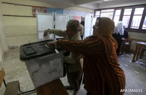An Egyptian woman casts her ballot at a polling station during the second round of a referendum on a new draft constitution in Giza, south of Cairo, on December 22, 2012. Egyptians are voting in the final round of a refe...