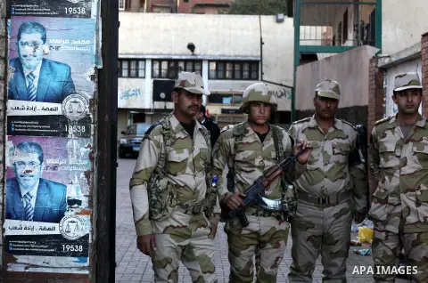 Members of Egyptian army stand guard at the entrance of the polling station, during the second round of a referendum for the new Egyptian constitution, in Giza, south of Cairo, Egypt, 22 December 2012. More than 25 milli...