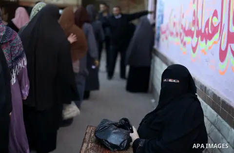 Egyptian women queue with other voters at a polling station during the second round of a referendum on a new draft constitution in Giza, south of Cairo, on December 22, 2012. Egyptians are voting in the final round of a...