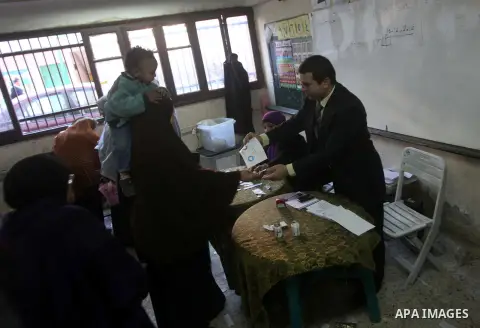 Egyptian women casts her ballot at a polling station during the second round of a referendum on a new draft constitution in Giza, south of Cairo, on December 22, 2012. Egyptians are voting in the final round of a referen...