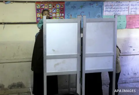 Egyptian women casts her ballot at a polling station during the second round of a referendum on a new draft constitution in Giza, south of Cairo, on December 22, 2012. Egyptians are voting in the final round of a referen...