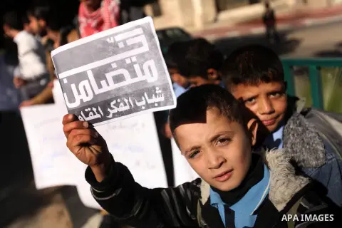 Palestinians children hold a poster to show his support for Palestinian prisoners currently being held in Israeli jails, some of whom are on hunger strike, in Gaza city, 23, 2012. Photo by Majdi Fathi