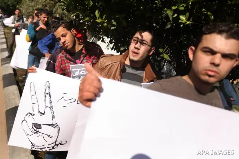 Palestinians youth hold a poster to show his support for Palestinian prisoners currently being held in Israeli jails, some of whom are on hunger strike, in Gaza city, 23, 2012. Photo by Majdi Fathi