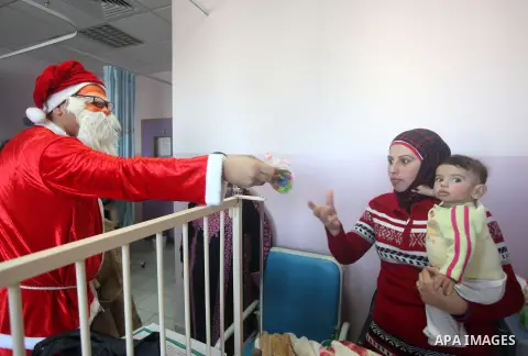 Palestinian Man dressed as Santa Claus give the Children a present in the hospital in the West Bank city of Ramallah on 23 December 2012 .Palestinian Christians across the Israeli occupied Palestinian West Bank are prepa...