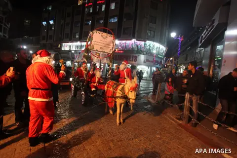 A Palestinian dressed as Santa Claus rides a cart pulled by a donkey in the West Bank city of Ramallah ahead of Christmas on December 23, 2012.Christians across the Israeli occupied Palestinian West Bank are preparing fo...