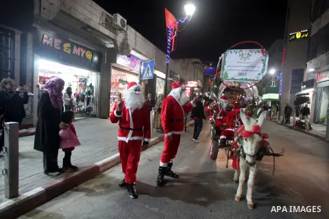 A Palestinian dressed as Santa Claus rides a cart pulled by a donkey in the West Bank city of Ramallah ahead of Christmas on December 23, 2012.Christians across the Israeli occupied Palestinian West Bank are preparing fo...