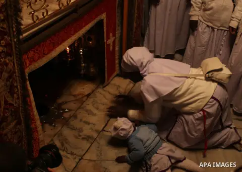 Pilgrims are seen near the 'Grotto,' where Christians believe the Virgin Mary gave birth to Jesus Christ, in the Church of the Nativity, in the West Bank town of Bethlehem on Christmas Day, 24 December 2012. Photo by Iss...