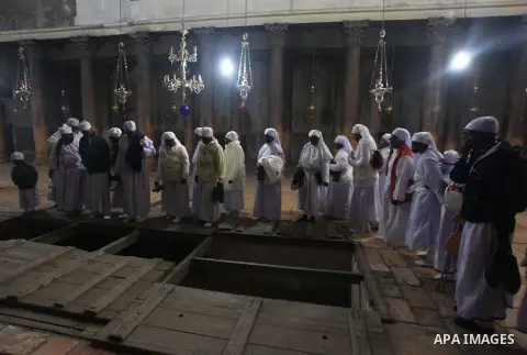 Pilgrims are seen near the 'Grotto,' where Christians believe the Virgin Mary gave birth to Jesus Christ, in the Church of the Nativity, in the West Bank town of Bethlehem on Christmas Day, 24 December 2012. Photo by Iss...