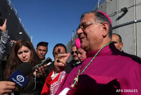 The Latin Patriarch of Jerusalem Fuad Twal, the head of the Roman Catholic Church in the Holy Land, talks to media as he arrives in the West Bank city of Bethlehem after crossing Israel's separation barrier on December 2...