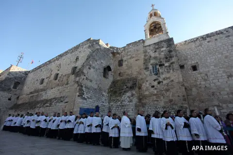 Members of the clergy wait for the arrival of the Latin Patriarch of Jerusalem Fouad Twal outside the Church of the Nativity, the site revered as the birthplace of Jesus, in the West Bank city of Bethlehem December 24, 2...