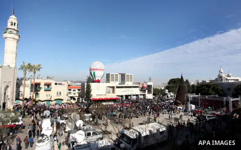 Palestinians wait for the arrival of the Latin Patriarch of Jerusalem Fouad Twal outside the Church of the Nativity, the site revered as the birthplace of Jesus, in the West Bank city of Bethlehem December 24, 2012. Phot...
