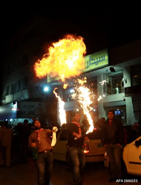 A Palestinian man spews fire from his mouth as he attends the Christmas celebrations in the West Bank city of Nablus on Dec. 24, 2012. Photo by Nedal Eshtayah