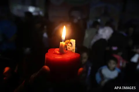 A Palestinian woman holds a candle during a candlelight rally in solidarity with hunger-striking detainees held by Israel in Gaza city to demand their release from detention without trial. December 25, 2012. Photo by Maj...
