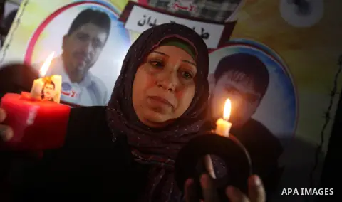 A Palestinian woman holds a candle during a candlelight rally in solidarity with hunger-striking detainees held by Israel in Gaza city to demand their release from detention without trial. December 25, 2012. Photo by Maj...