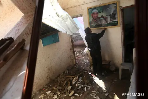 A Palestinian man puts a portrait of his killed son on the wall at his bombed house, marking the 4 th anniversary of his death during the Israel-Gaza war, in Gaza City, on Dec. 26, 2012. The three-week offensive dramatic...