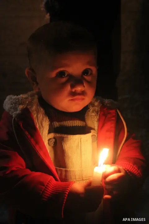 Palestinian children hold candles during a candlelight vigil in front of Red Cross offices, solidarity with hunger-striking detainees held by Israel in Gaza city to demand their release from detention without trial. Dece...