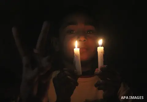 Palestinian children hold candles during a candlelight vigil in front of Red Cross offices, solidarity with hunger-striking detainees held by Israel in Gaza city to demand their release from detention without trial. Dece...