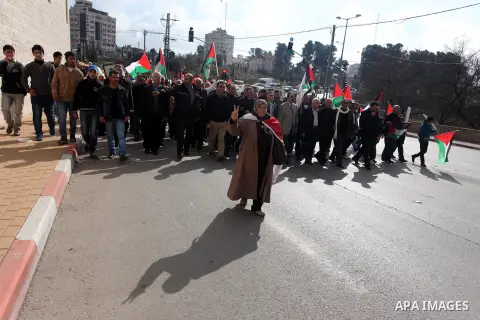 Palestinians hold placards and their national flags during a demonstration in the West Bank city of Ramallah calling for an end in the political division and commitment to the reconciliation agreement between rival Pales...
