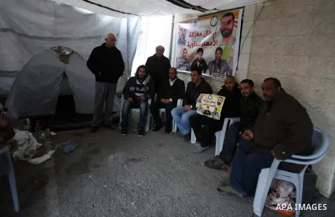 Palestinians gather in front of the Red Cross offices during sit-in outside the Red Cross offices to show solidarity with Palestinian prisoner Samer Issawi who held in an Israeli jail and on hunger strike since August 1...