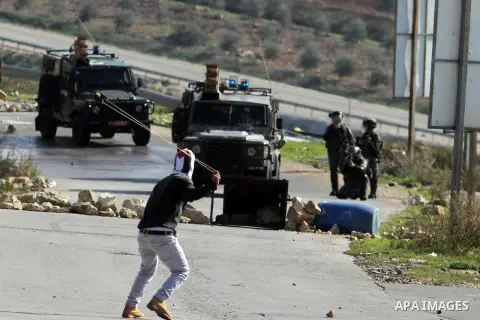 A Palestinian protester uses a sling to throw stones at Israeli security officers during clashes at a protest against Jewish settlements, in the West Bank village of Nabi Saleh, near Ramallah December 28, 2012. Photo by...
