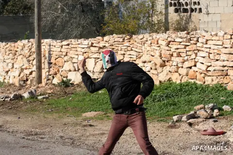 A Palestinian demonstrator throws stones at Israeli soldiers during clashes at the weekly protest against the Jewish settlement of Qadomem, near Nablus, West Bank, 28 December 2012. According to Palestinian sources, five...