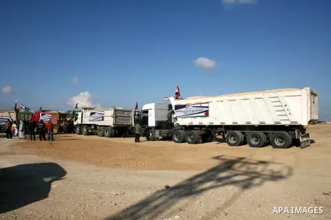 Palestinian men stand near trucks of supplying raw materials of Qatari grant projects in Rafah crossing in the southern Gaza Strip. Egypt allowed access supplying raw materials of Qatari grant projects Through the Rafah...