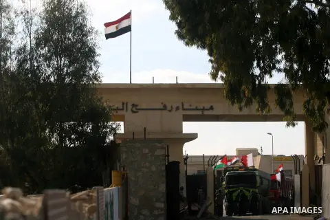 Palestinian men stand near trucks of supplying raw materials of Qatari grant projects in Rafah crossing in the southern Gaza Strip. Egypt allowed access supplying raw materials of Qatari grant projects Through the Rafah...
