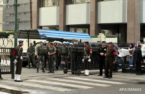 Egyptian riot police stand guard outside the Shura Council, the upper house of parliament where the Constituent Assembly drafted the country's new constitution, as protesters against Egypt's President Mohamed Morsi chant...