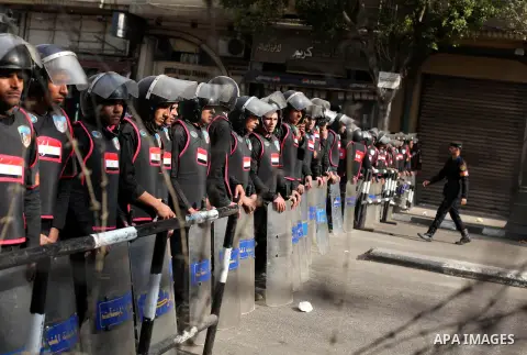 Egyptian riot police stand guard outside the Shura Council, the upper house of parliament where the Constituent Assembly drafted the country's new constitution, as protesters against Egypt's President Mohamed Morsi chant...