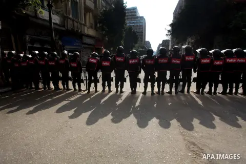 Egyptian riot police stand guard outside the Shura Council, the upper house of parliament where the Constituent Assembly drafted the country's new constitution, as protesters against Egypt's President Mohamed Morsi chant...