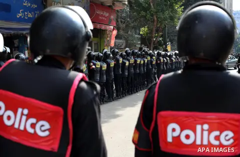 Egyptian riot police stand guard outside the Shura Council, the upper house of parliament where the Constituent Assembly drafted the country's new constitution, as protesters against Egypt's President Mohamed Morsi chant...
