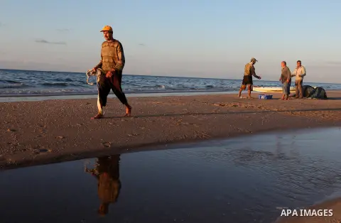 Palestinian fishers prepare to throw their trawl in the sea during sunset on the beach of Gaza city,on December 29, 2012. Photo by Majdi Fathi