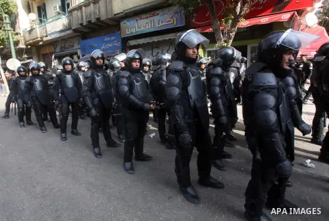 Egyptian riot police stand guard outside the Shura Council, the upper house of parliament where the Constituent Assembly drafted the country's new constitution, as protesters against Egypt's President Mohamed Morsi chant...