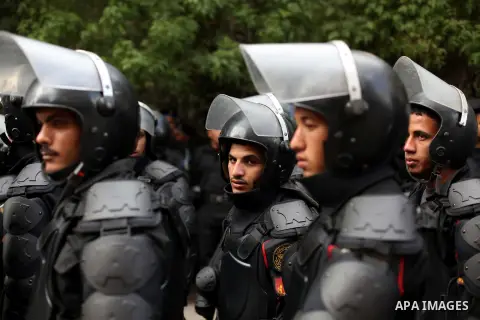 Egyptian riot police stand guard outside the Shura Council, the upper house of parliament where the Constituent Assembly drafted the country's new constitution, as protesters against Egypt's President Mohamed Morsi chant...