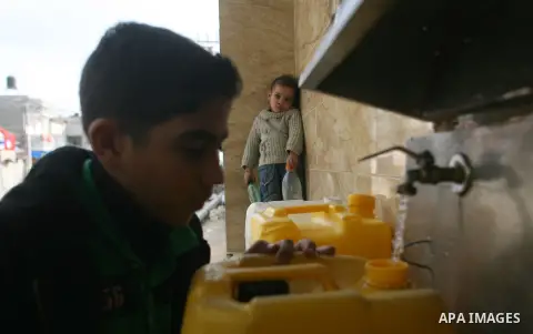 Palestinian children fill plastic bottles with drinking water in Rafah camp southern Gaza Strip, on Dec. 30, 2012. The residents of the Gaza strip suffer from lack of potable water, Israel continues to tighten its blocka...