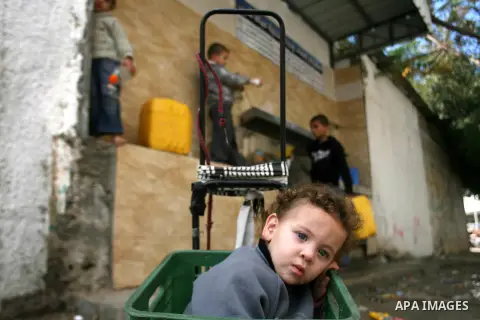 Palestinian children fill plastic bottles with drinking water in Rafah camp southern Gaza Strip, on Dec. 30, 2012. The residents of the Gaza strip suffer from lack of potable water, Israel continues to tighten its blocka...